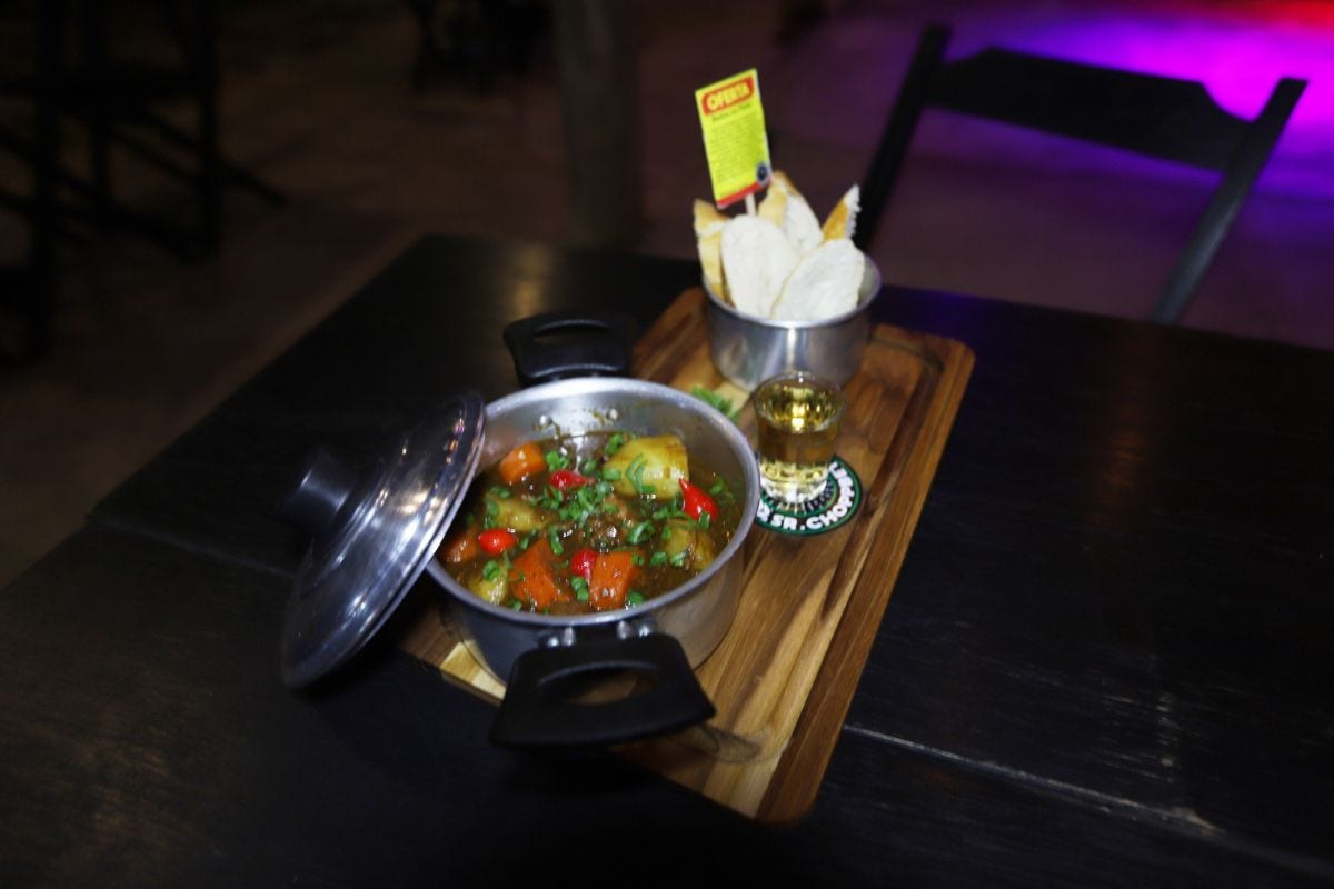 Prato combina tradição e releitura, servido com pãozinho de sal e molho de cerveja preta
