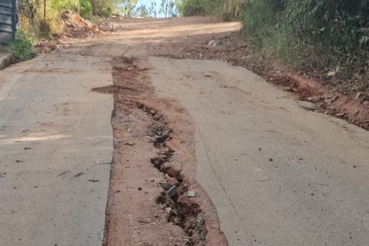 Com a chegada das chuvas, a enxurrada removeu o aterro e espalhou pedregulhos, abrindo grandes buracos na rua