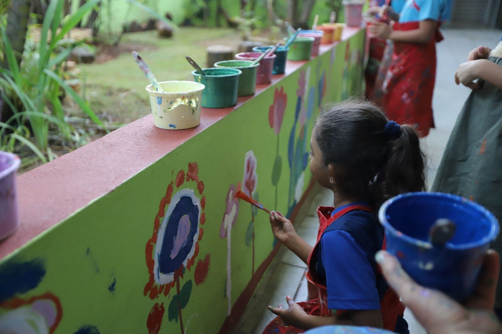 Crianças participaram da pintura de um jardim florido no pátio da creche