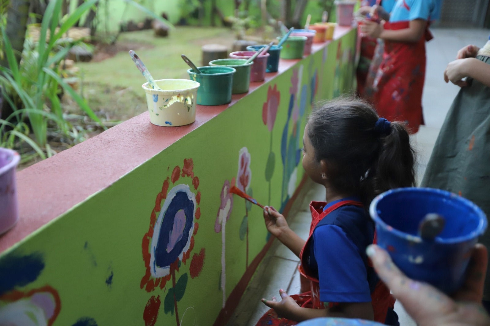 Crianças participaram da pintura de um jardim florido no pátio da creche