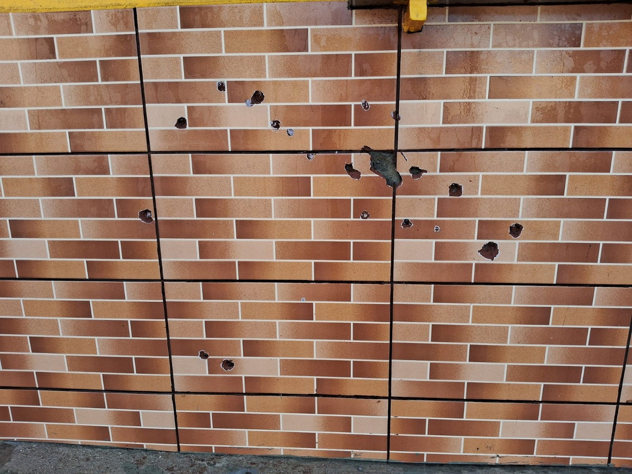 Marcas dos tiros ficaram na parede de comércio na rua