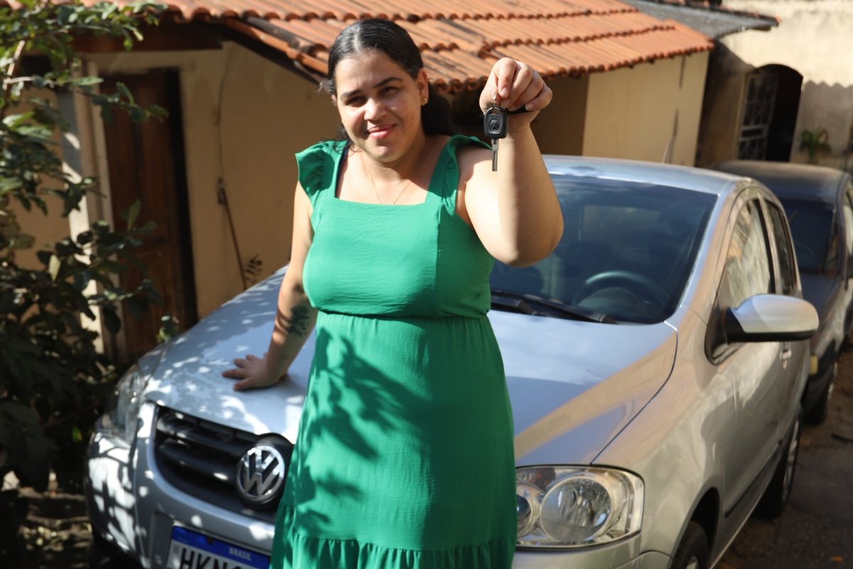 Mulher mostra, com felicidade, presente recebido