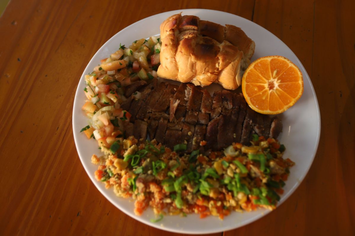 Copa lombo suculento servido com pão de alho, limão capeta e vinagrete, completado pela farofa de legumes com bacon e azeitona
