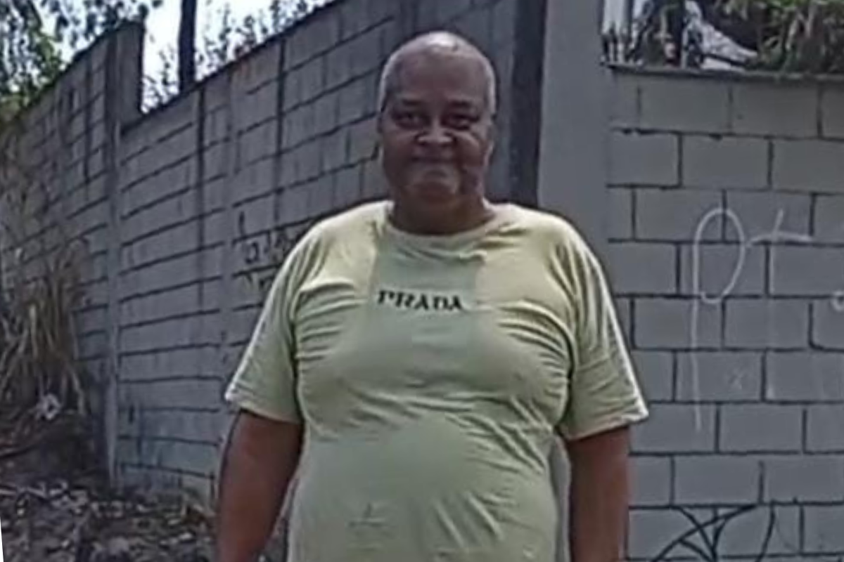 Ele vestia uma blusa verde clara de malha, calça preta e tênis preto